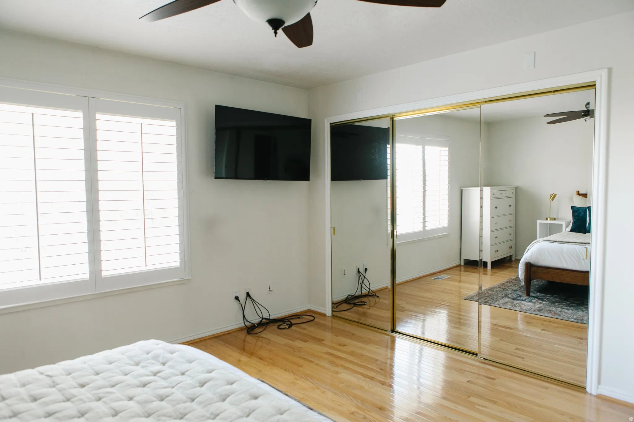 Hardwood flooring and dual mirrored closet doors define this bright room
