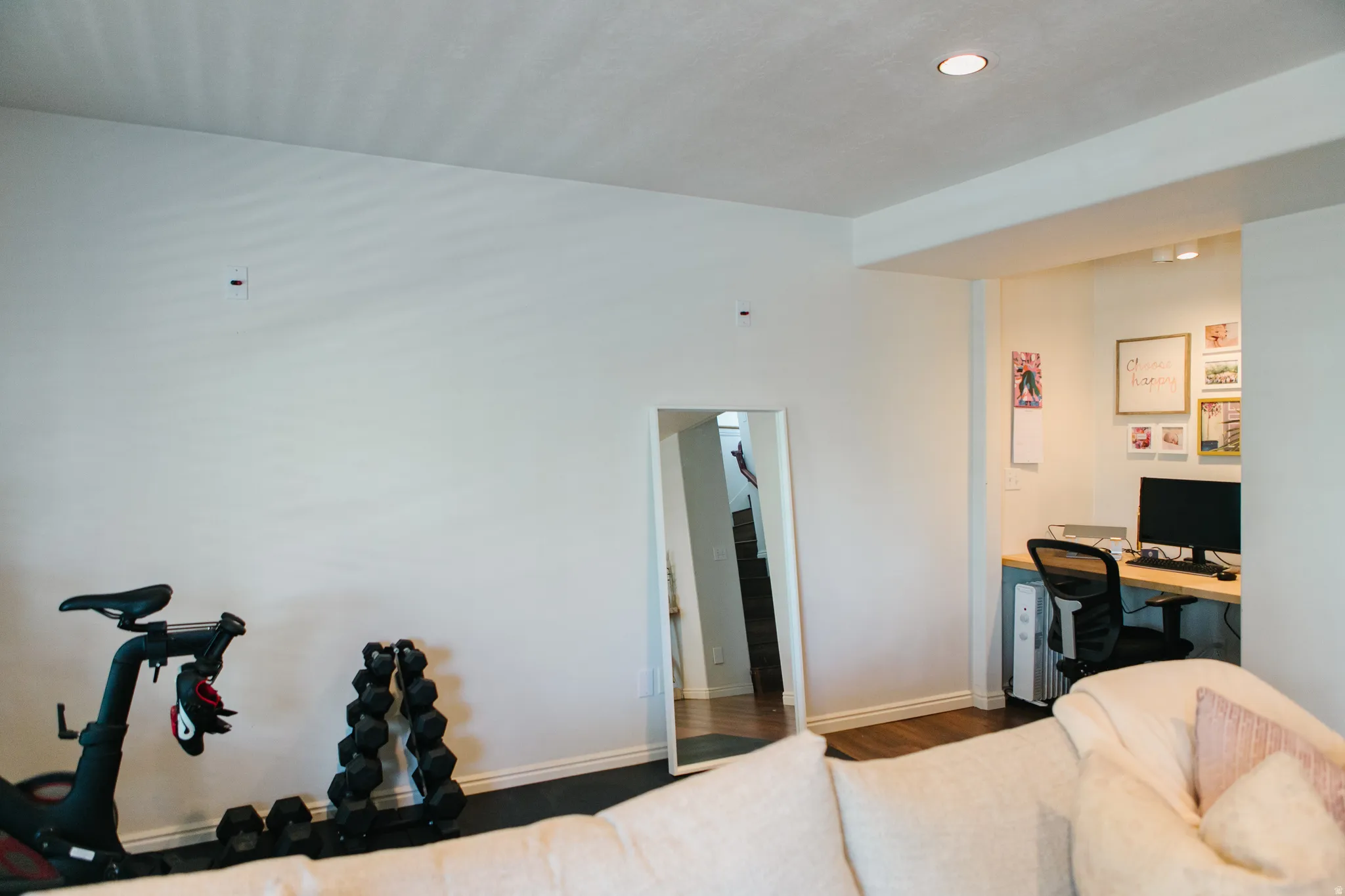 Recessed office nook with a built-in wood-finish desk, wood-finish flooring, and overhead track lighting