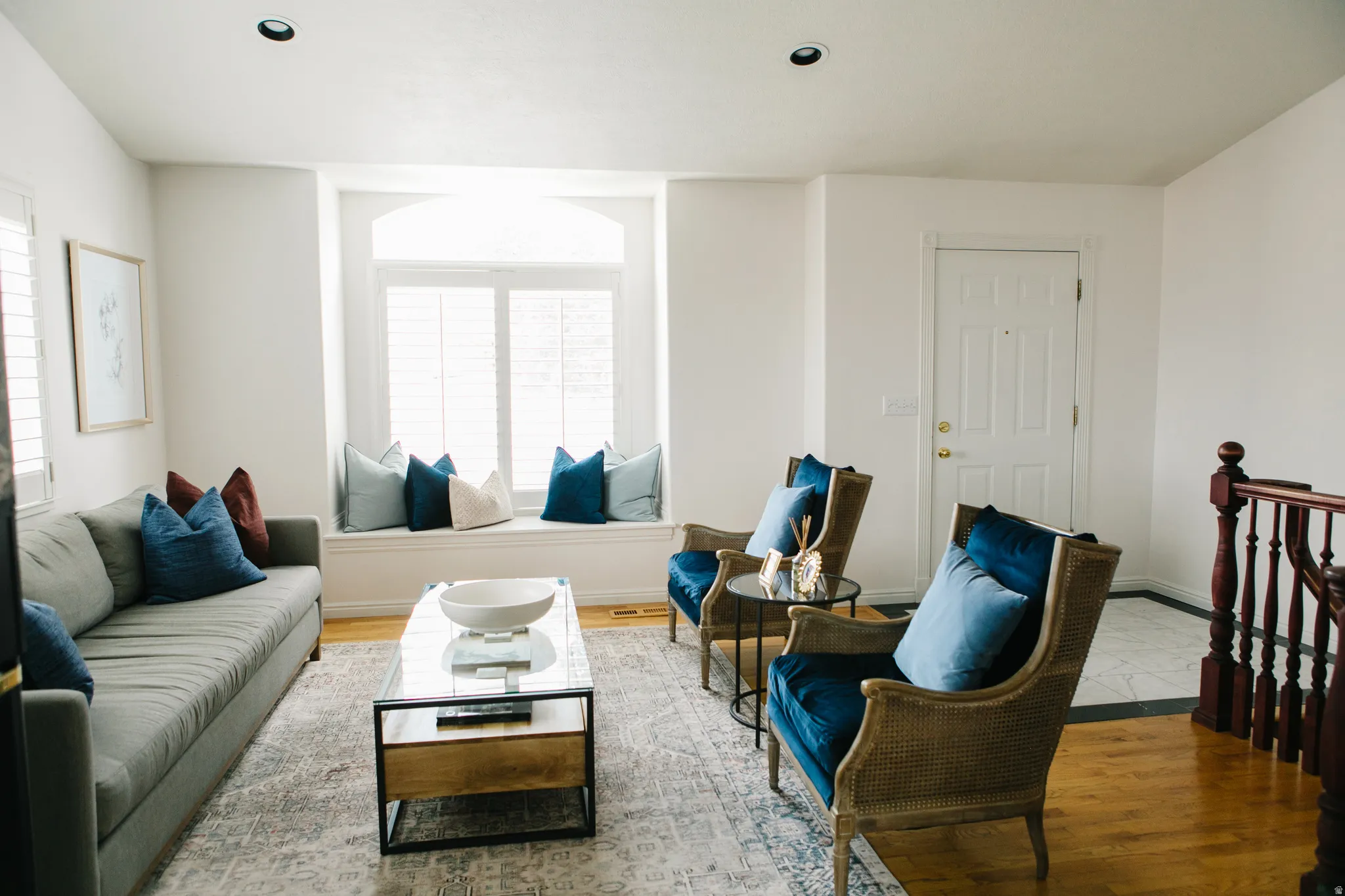 Living area featuring a wide box bay window seat with plantation shutters, recessed lighting, and wood flooring