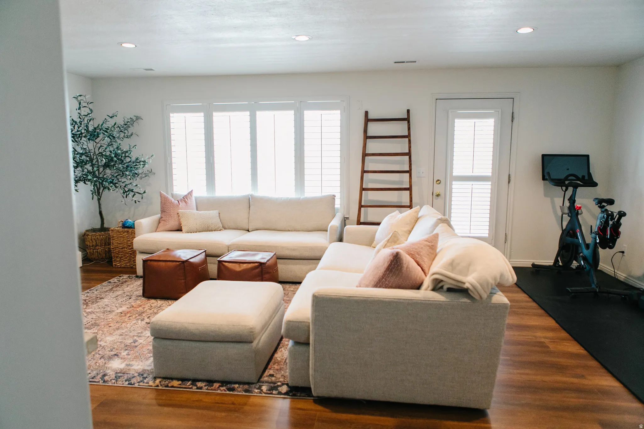 Spacious room featuring wood-finish flooring, recessed lighting, and white walls