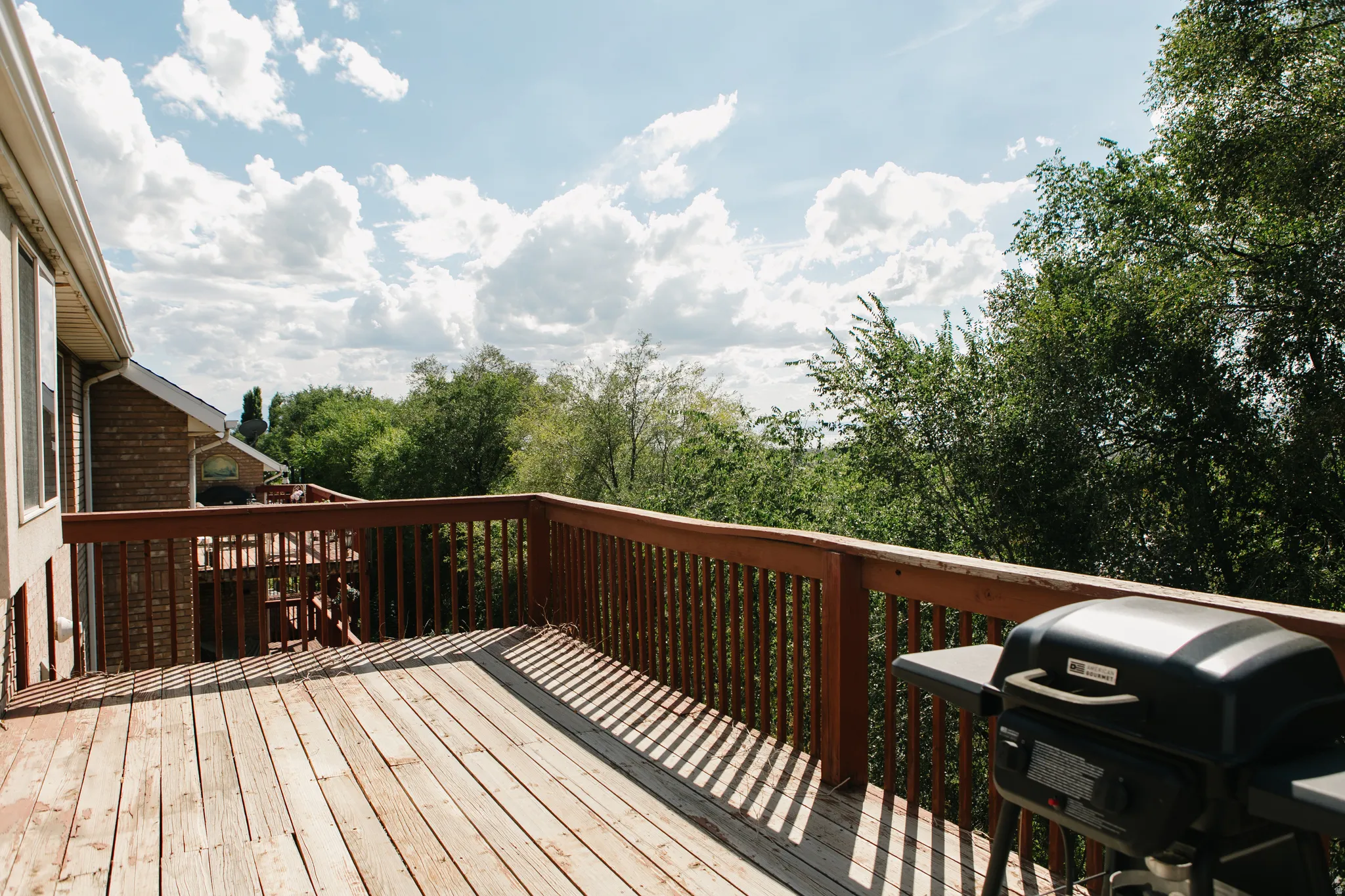 Expansive wooden deck featuring perimeter railing and ample space for outdoor enjoyment plus views