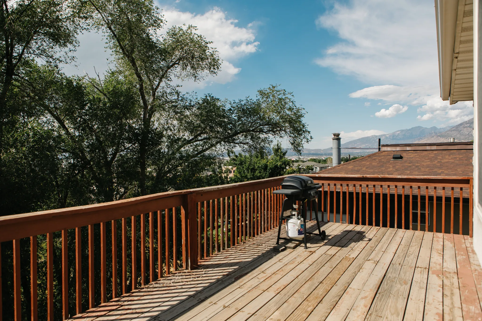Expansive wooden deck featuring horizontal plank flooring and a wood railing system