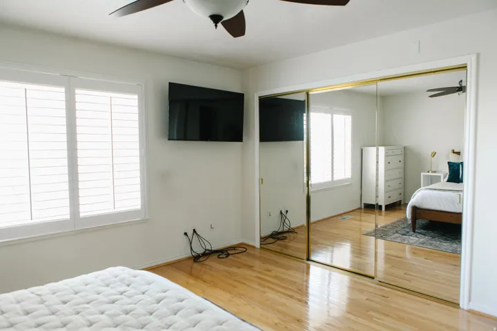 Hardwood flooring and dual mirrored closet doors define this bright room