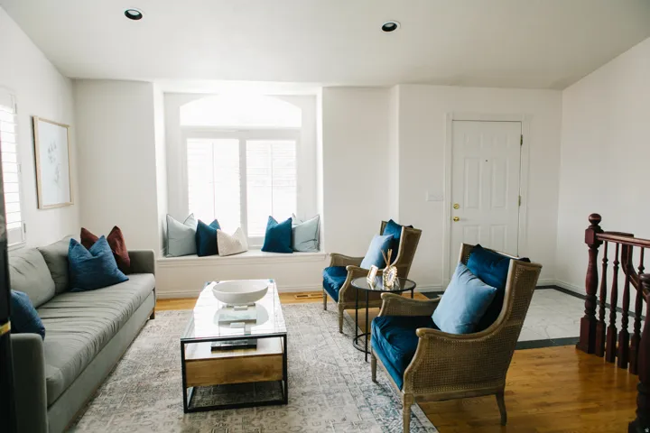 Living area featuring a wide box bay window seat with plantation shutters, recessed lighting, and wood flooring