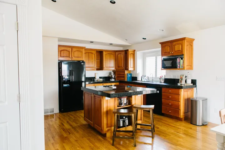 Kitchen featuring wood cabinetry, marble countertops, and a central island with integrated seating