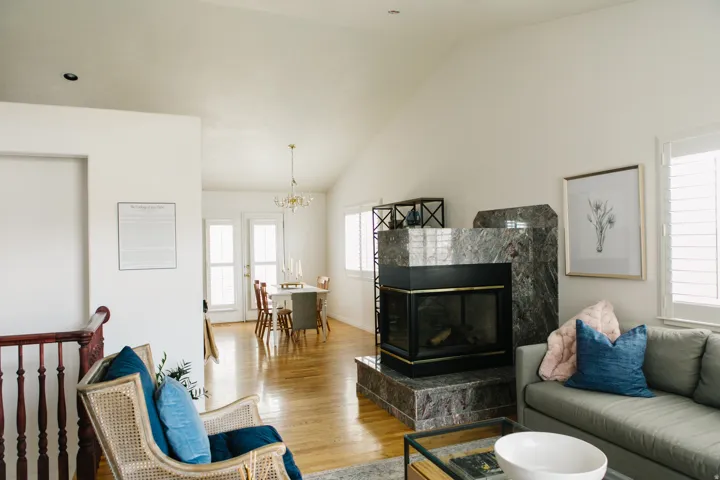 Spacious living area featuring a  fireplace, vaulted ceilings, and wood flooring