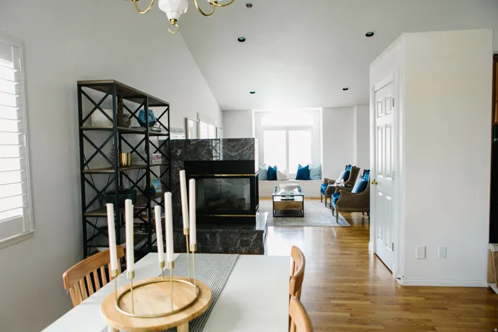 Open-concept living space with wood-flooring, a contemporary fireplace, recessed lighting, and a window seat with ample natural light