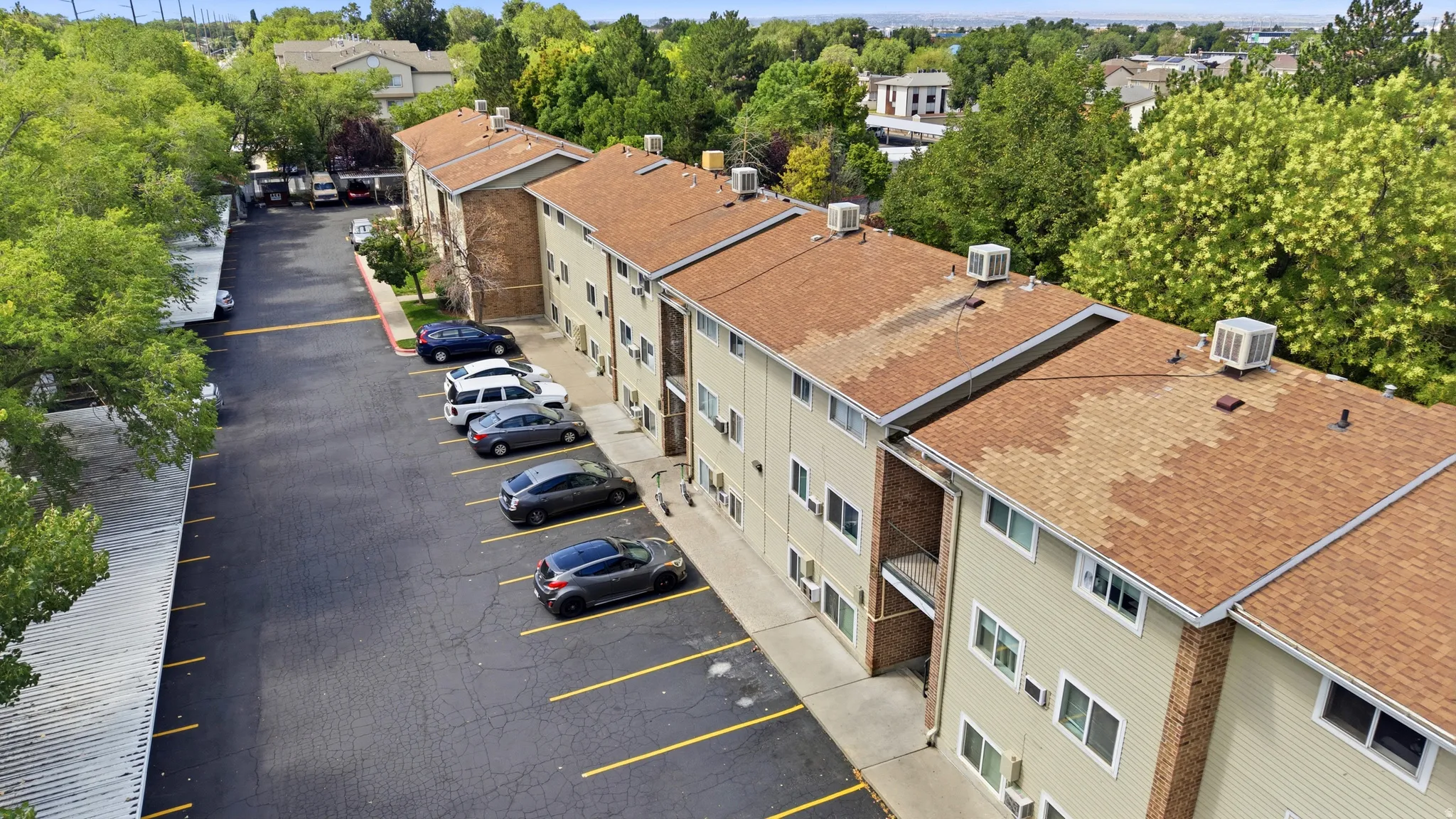 Multi-story residential buildings with tan siding and brick accents