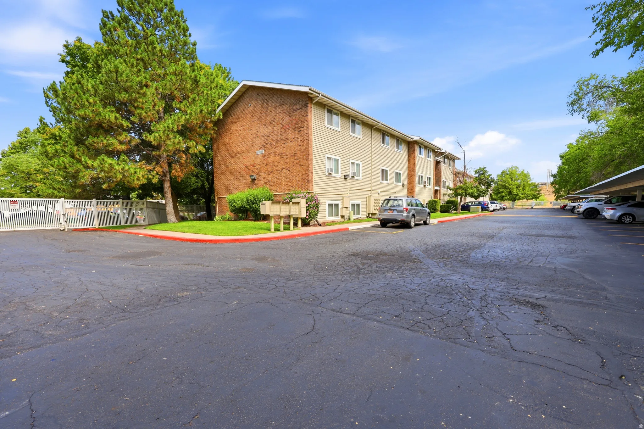 Building exterior featuring brick and siding finishes, multiple windows, and individual air conditioning units
