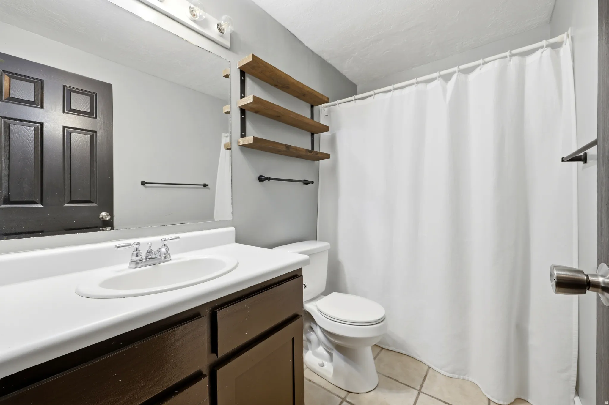 Bathroom featuring a dark wood-finish vanity with a white countertop and integrated sink