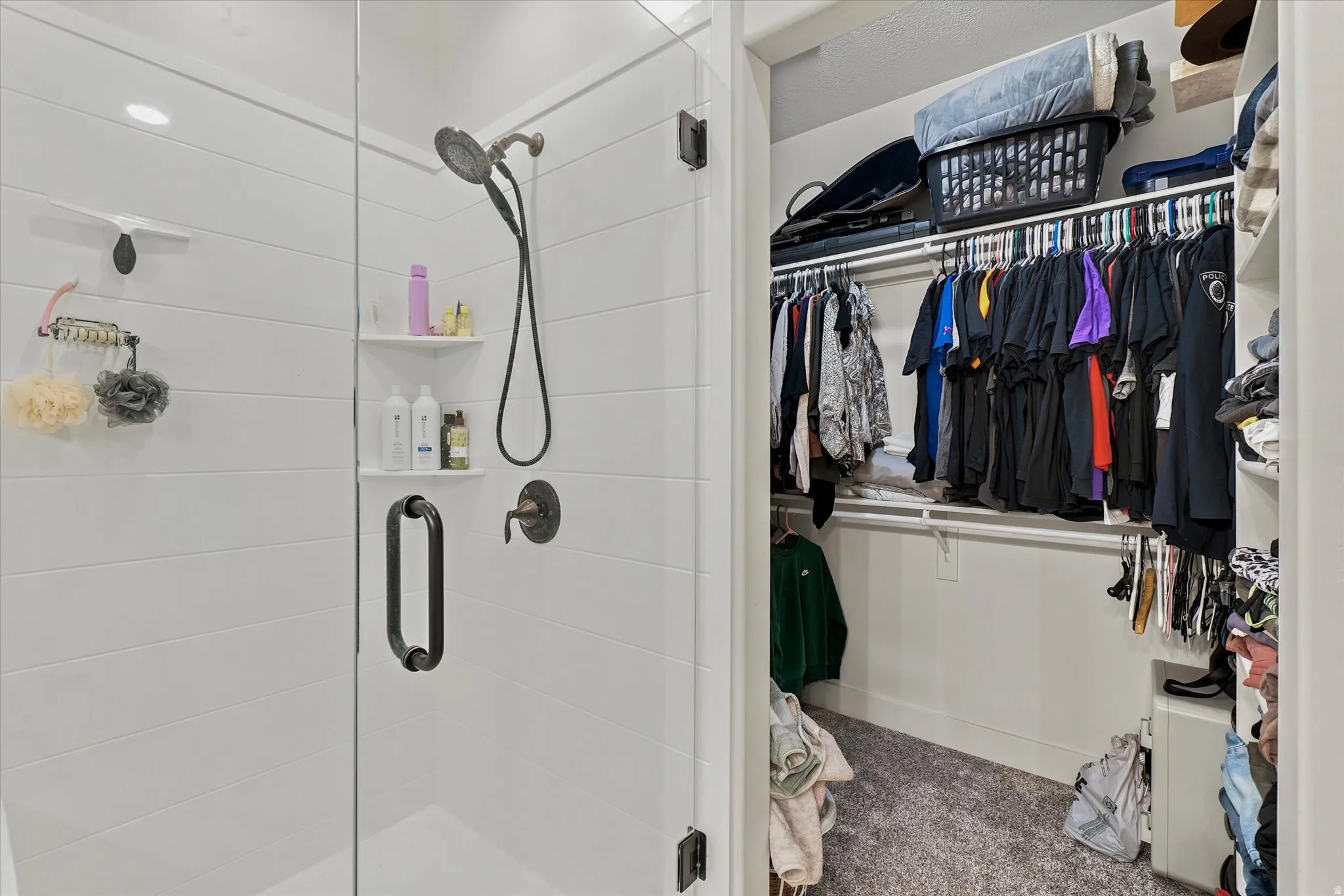 Glass-enclosed shower with horizontal white tile, built-in shelving, and dark bronze fixtures