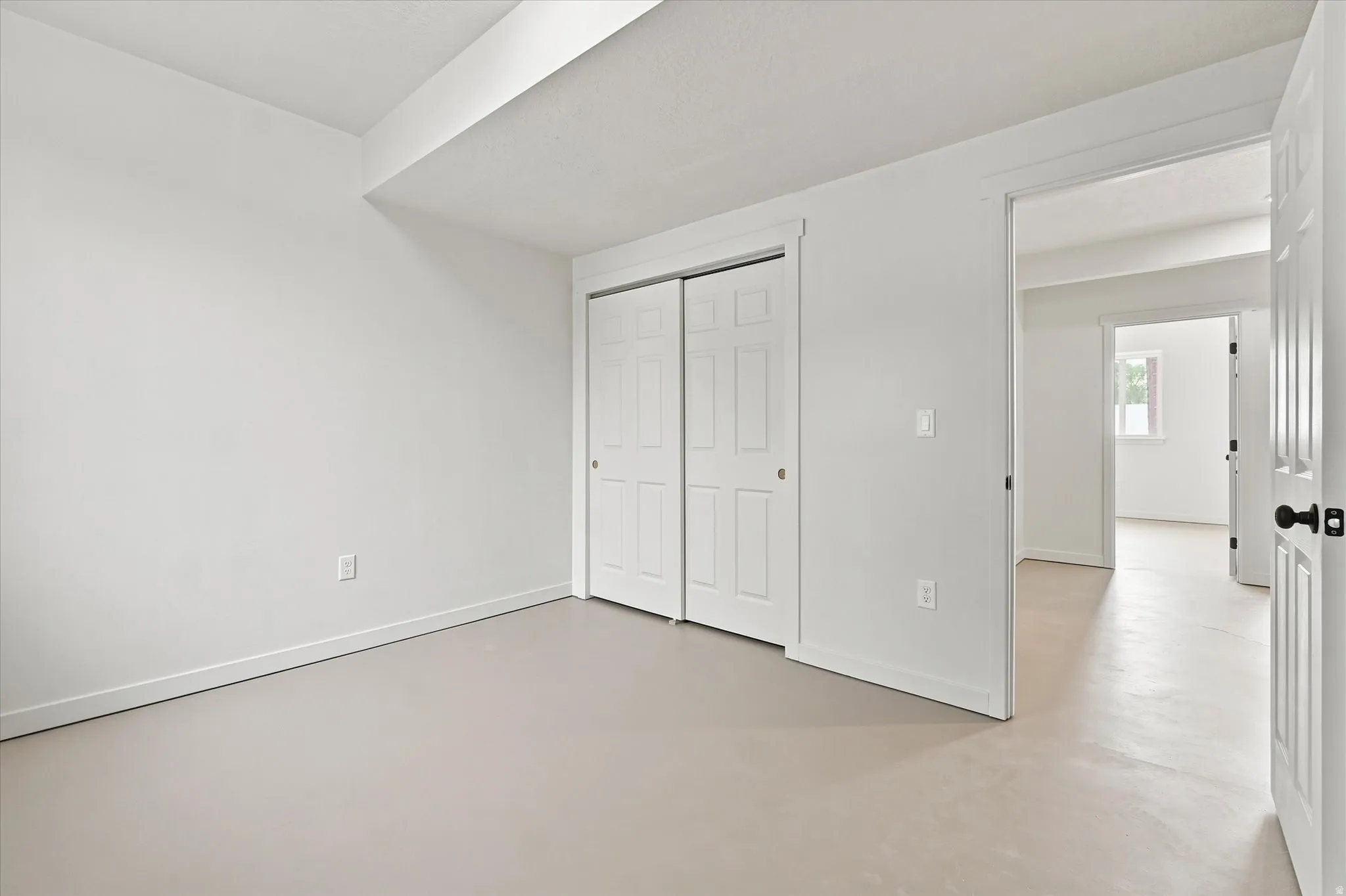 Room featuring light-toned flooring, white walls, and bright white trim
