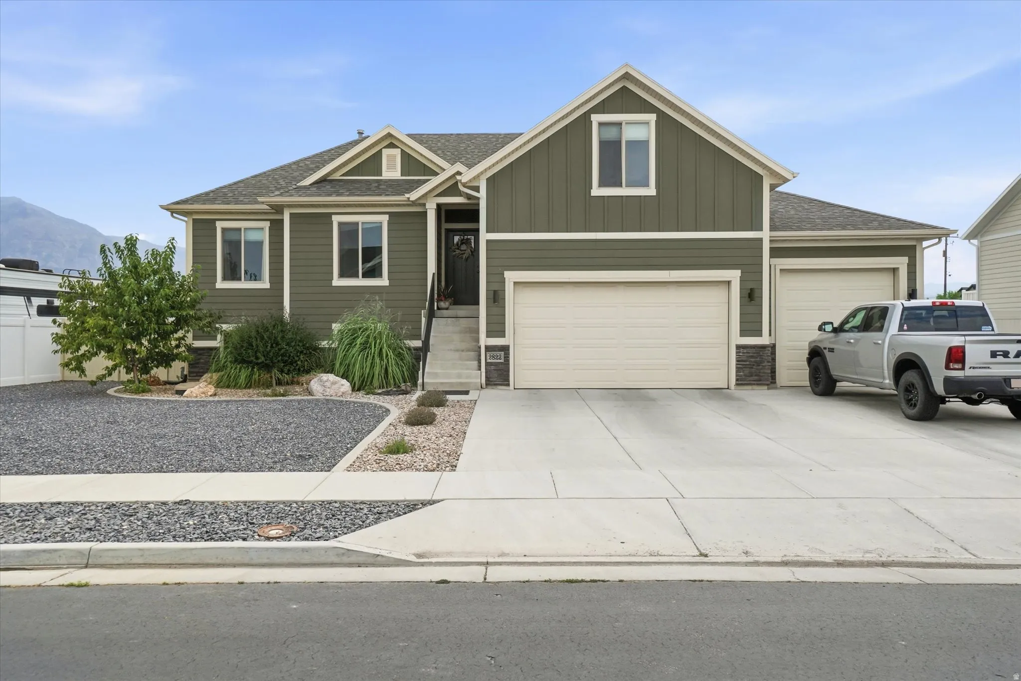 Two-story residence featuring a two-car garage and an additional single-car garage