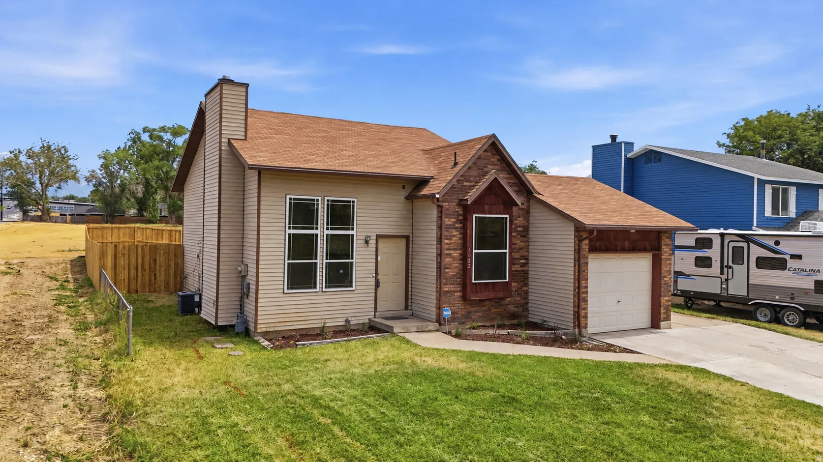 Two-story residence featuring a partial brick façade, beige siding, and a brown shingled roof