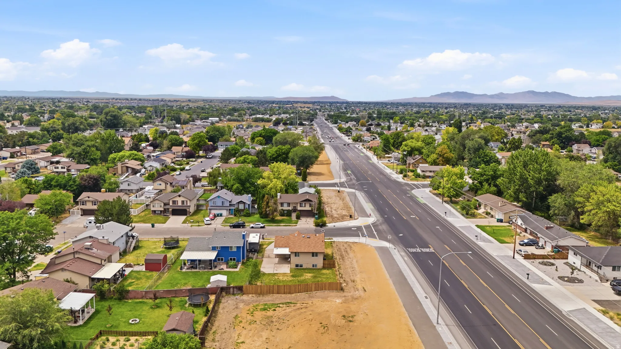 Expansive aerial perspective showcasing a residential neighborhood with established homes and mature trees
