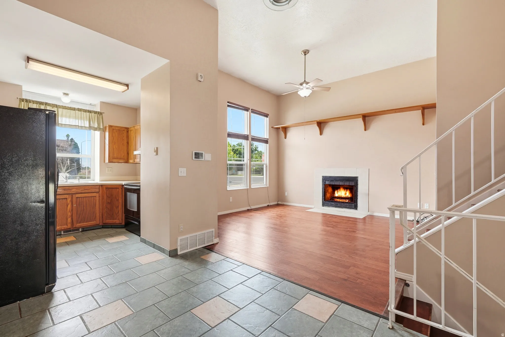 Living area with vaulted ceiling, large windows, and a built-in fireplace