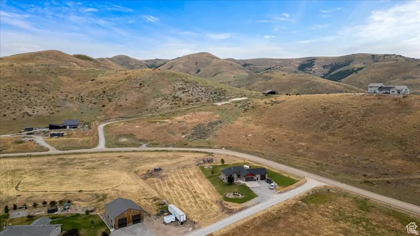 Expansive property featuring a contemporary residence with an attached garage, nestled among rolling hills