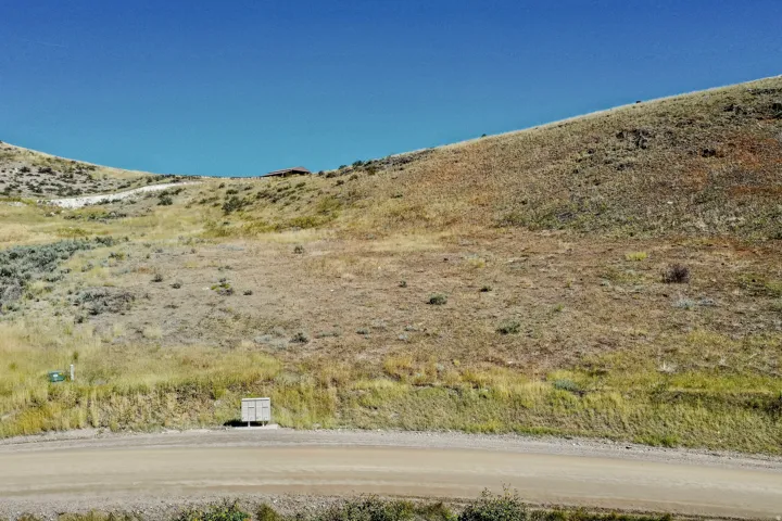 Expansive land parcel featuring natural terrain and a clear sky backdrop
