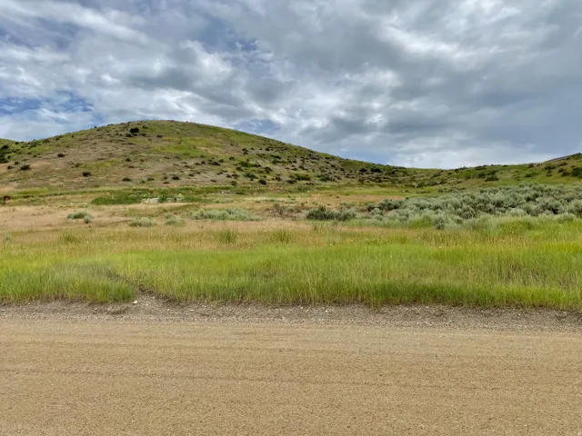 Expansive open terrain featuring rolling hills and varied vegetation