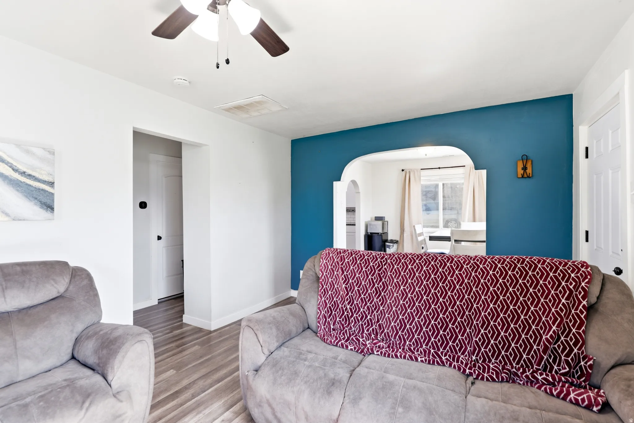 Bright interior space featuring wood-finish flooring and a ceiling fan