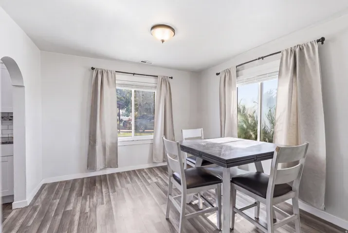 Spacious room featuring wood-finish flooring and white walls