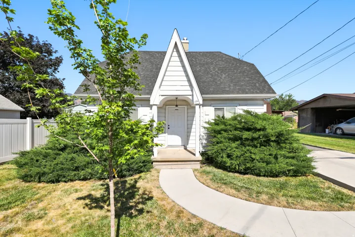 White siding home with a steep gable roofline and a covered entry porch