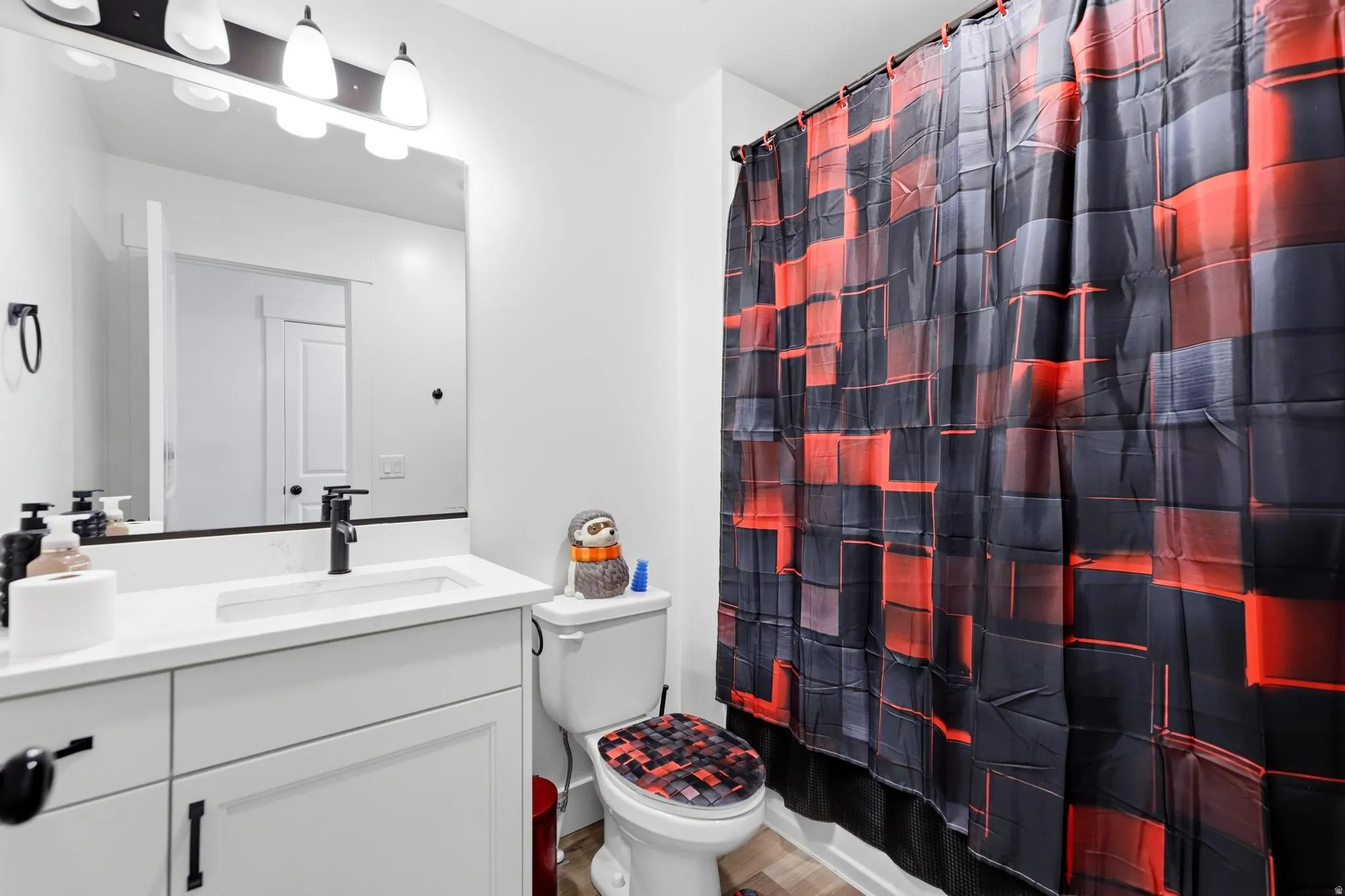 Bathroom featuring a single vanity with an integrated sink, white countertop, and dark-finish faucet