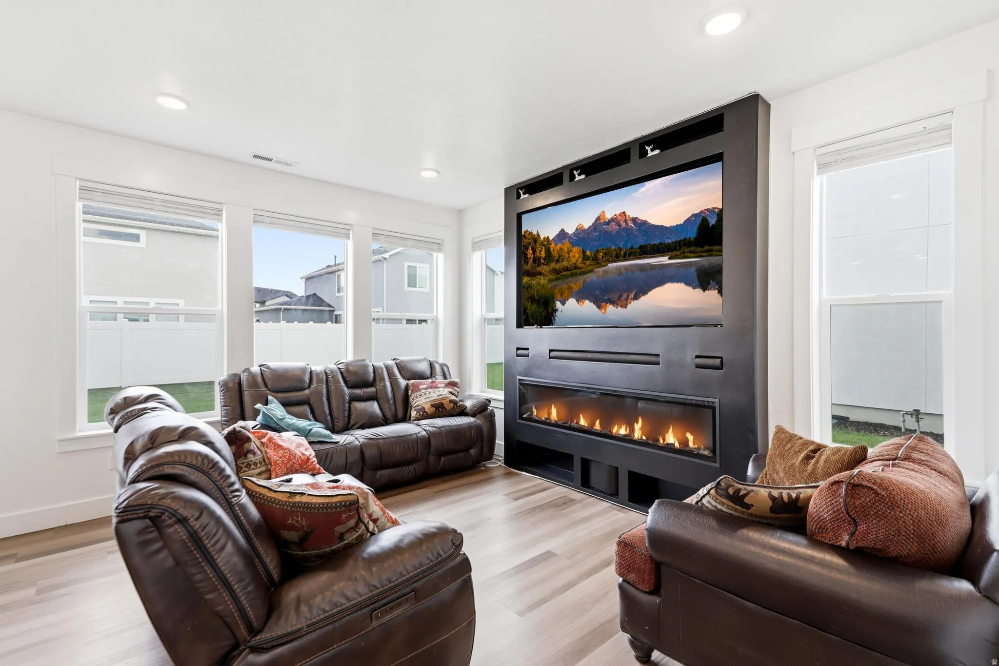 Integrated media wall featuring a wide screen and linear electric fireplace