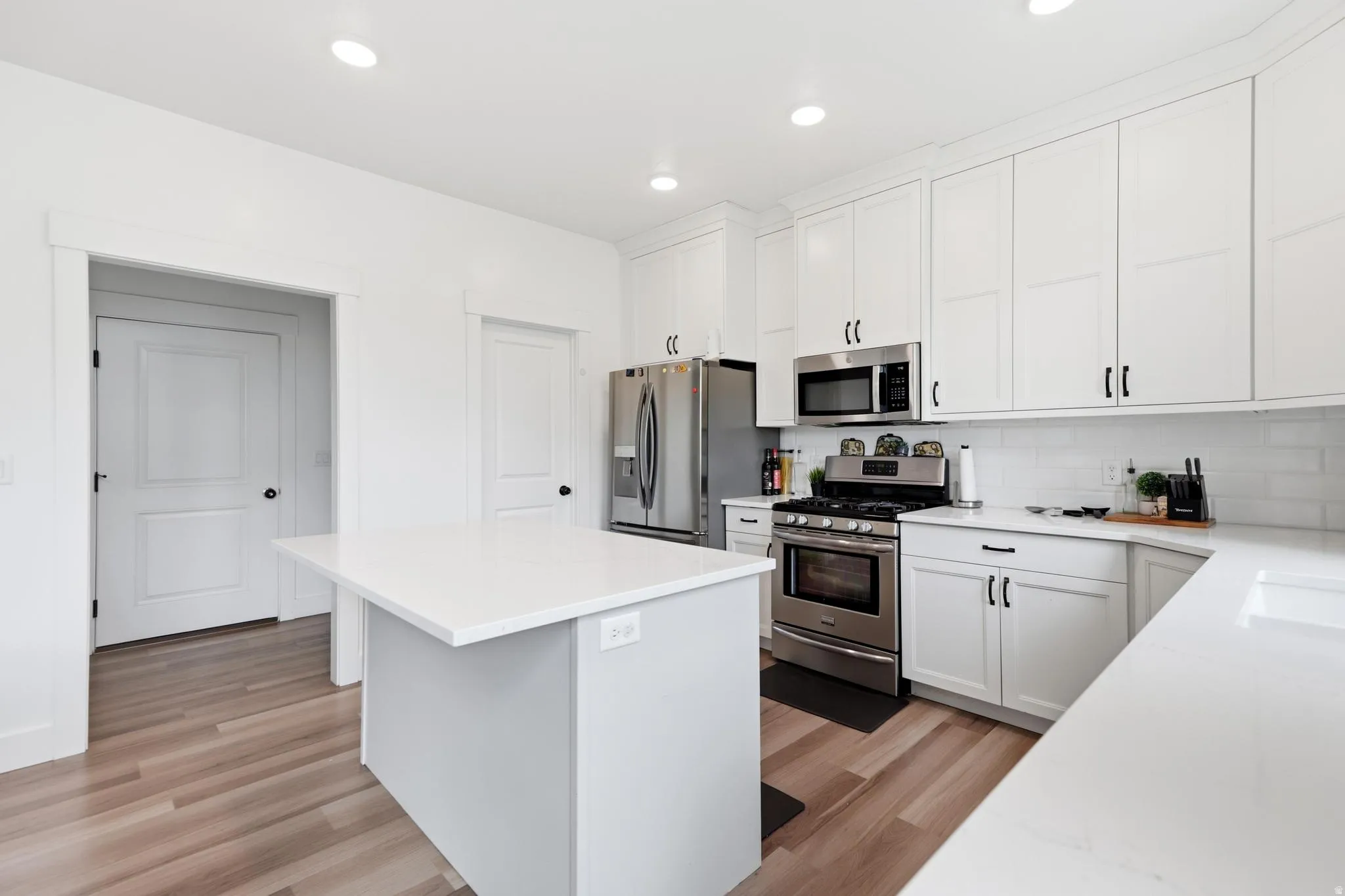 Modern kitchen featuring a central island with a white countertop