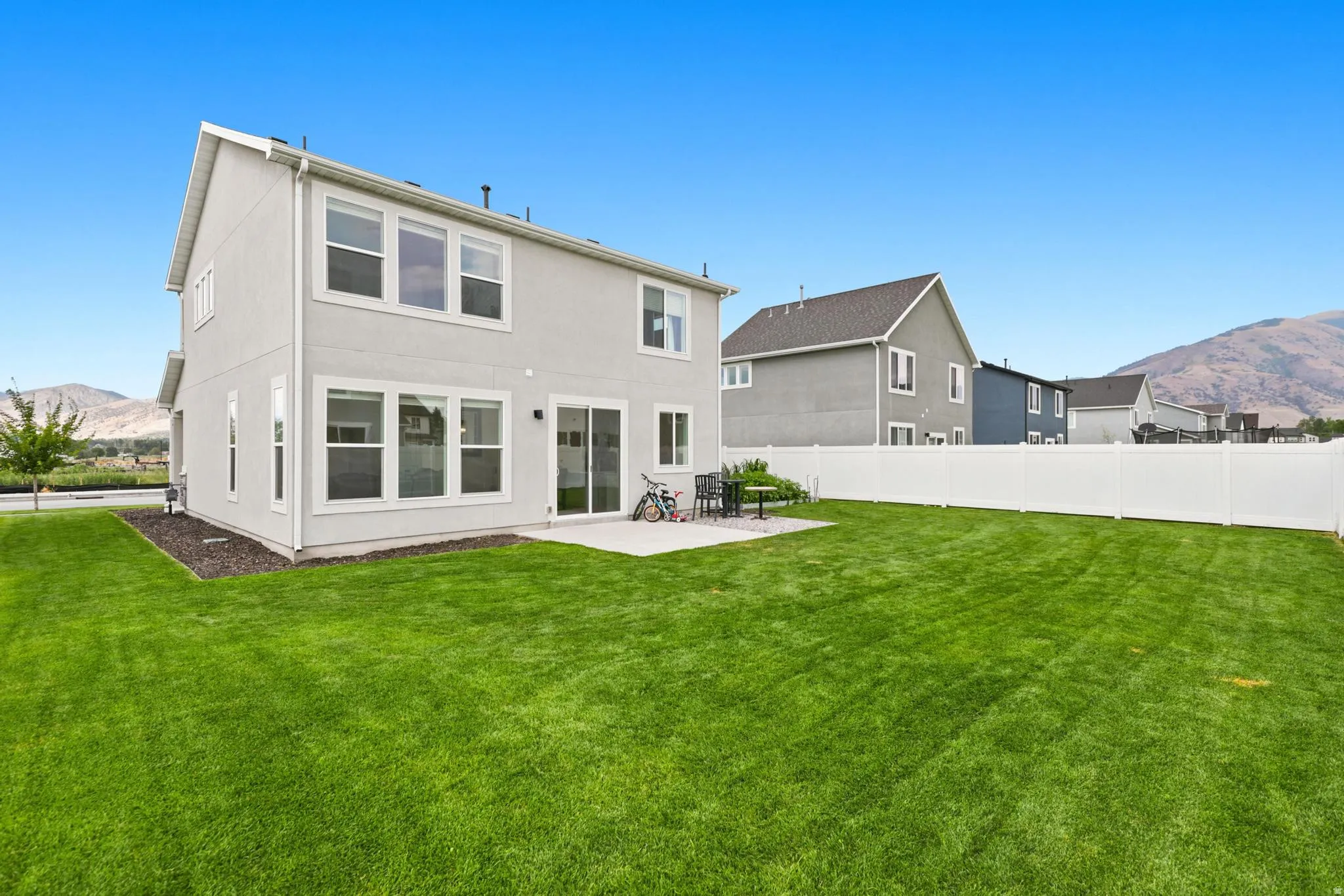 Expansive green lawn with a white vinyl fence
