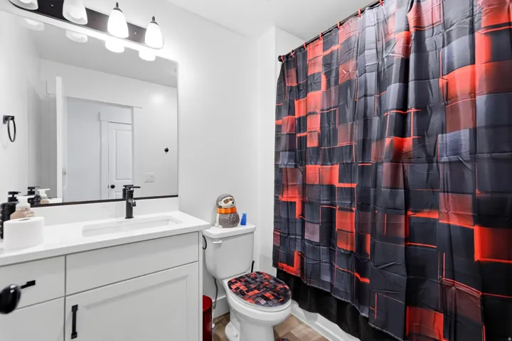 Bathroom featuring a single vanity with an integrated sink, white countertop, and dark-finish faucet