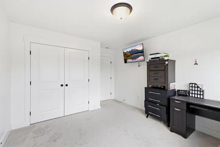 Light-toned wall-to-wall carpeting complements the bright white walls and trim