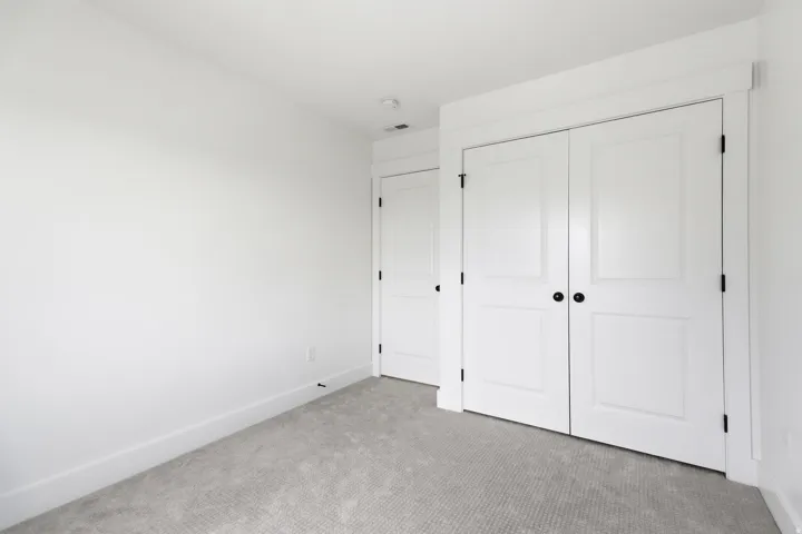 Room featuring neutral gray carpet, white painted walls, white baseboards, and a white ceiling