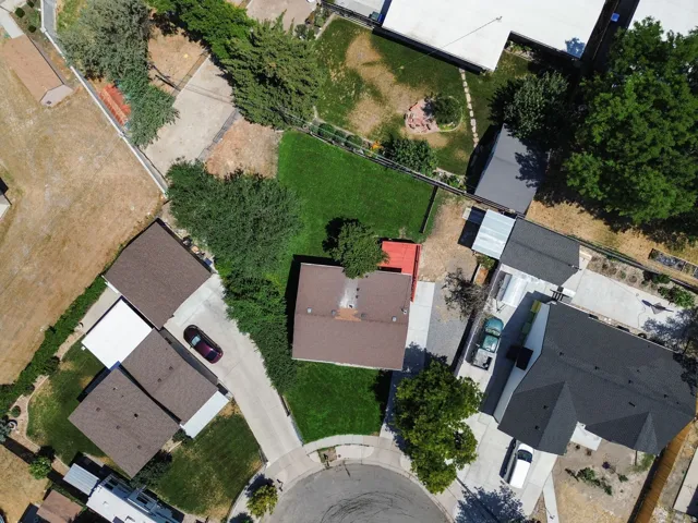 Property with a cul-de-sac location, featuring a brown shingle roof, a paved driveway, and established perimeter trees