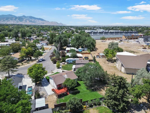 Suburban neighborhood with mature trees, established residential properties, and distant mountain ranges