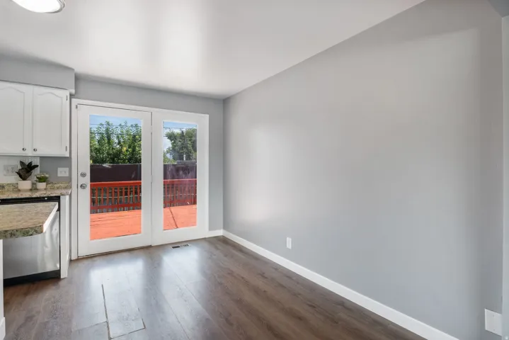 Kitchen dining area featuring wood-finish flooring, light gray walls, and white baseboards