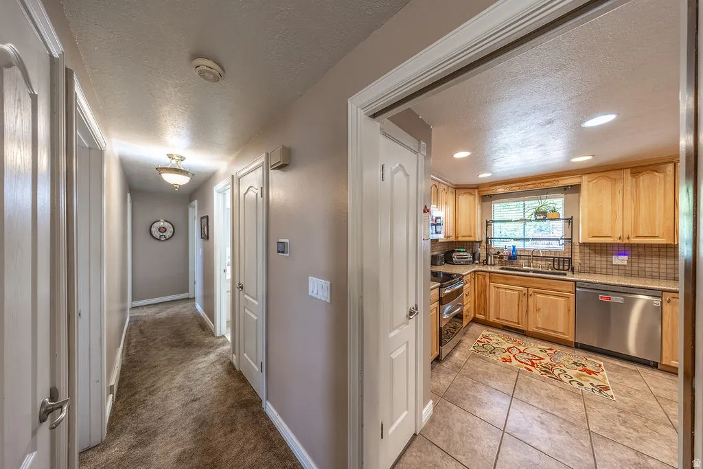 Kitchen featuring recessed lighting, a window, wood cabinetry, stainless steel appliances, and a tiled backsplash