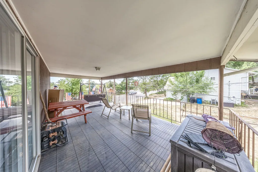 Covered porch featuring durable composite decking and a wrought-iron railing. Accessible from the master suite and the backyard.