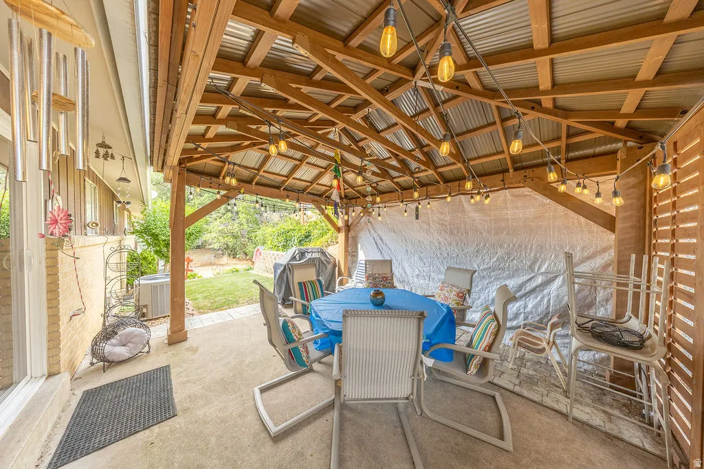Expansive covered patio featuring a corrugated metal roof and exposed wood beams