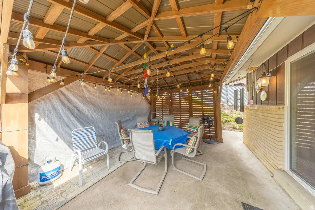 Outdoor patio with wood-framed pergola and corrugated metal roof. Pergola stays.