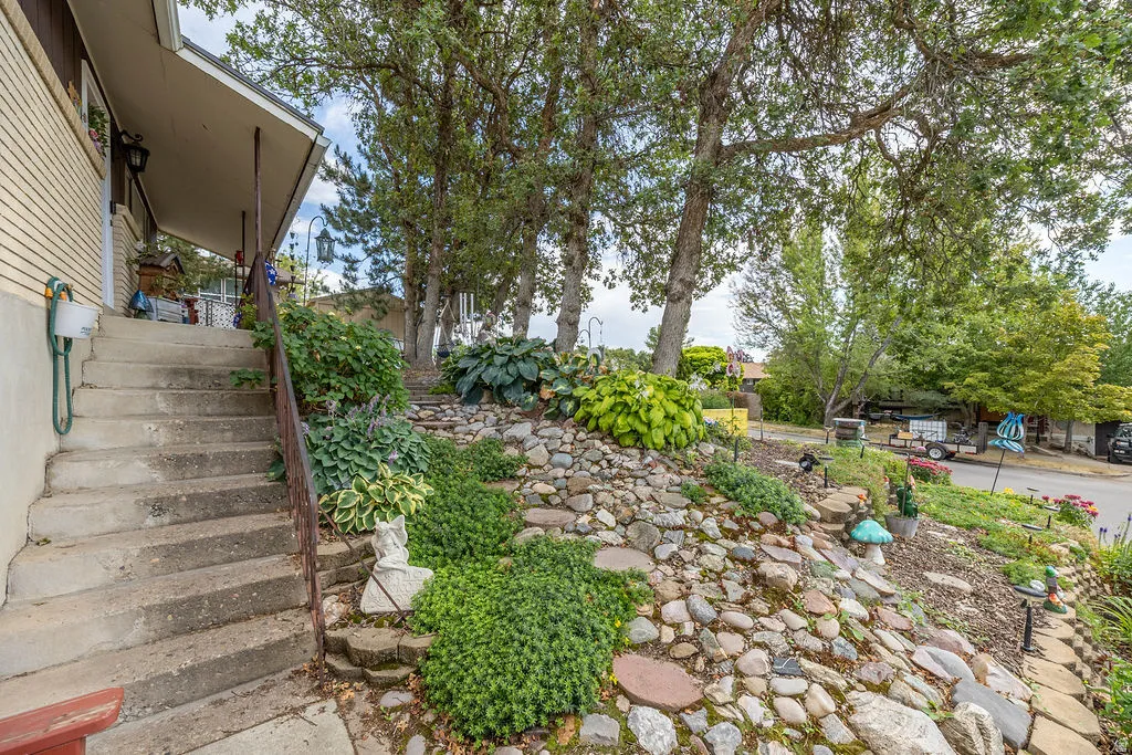 Concrete staircase leading to a covered porch with a partial brick exterior