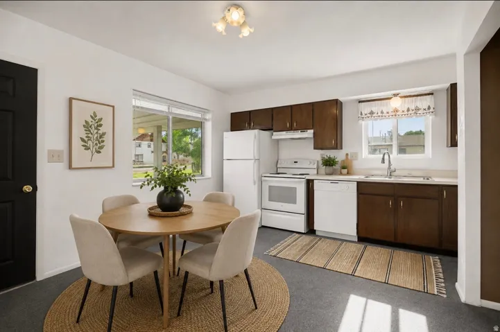 Kitchen featuring white appliances, dark wood-finish cabinetry, and a stainless-steel sink with a gooseneck faucet