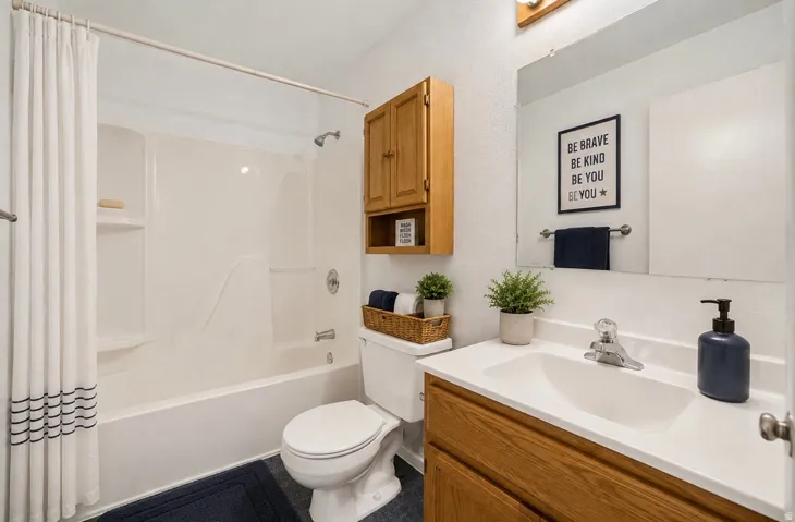 White tub and shower combination with chrome fixtures