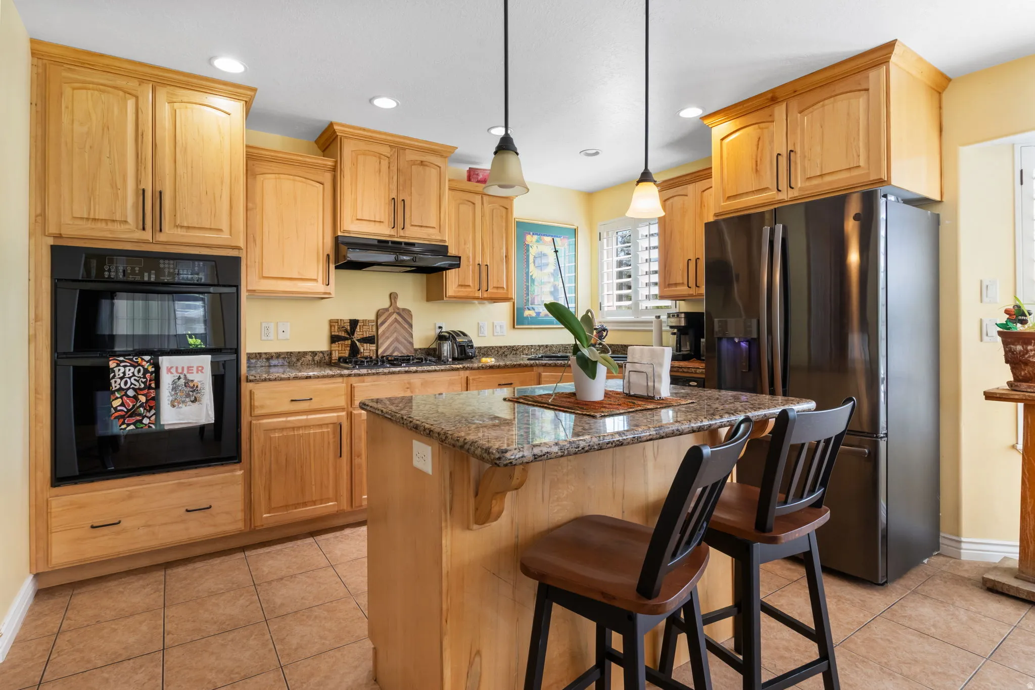 Kitchen featuring wood-finish cabinetry, granite countertops, and a built-in double oven