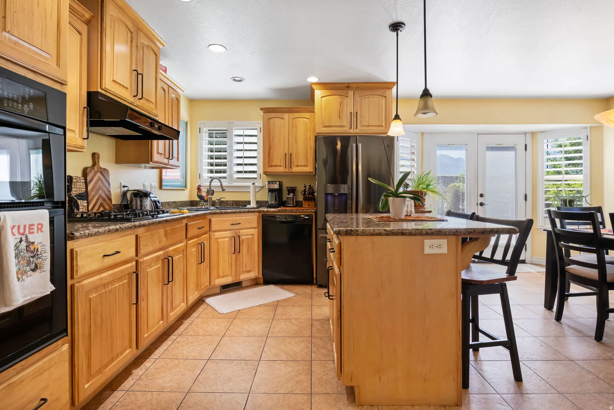 Kitchen featuring wood cabinetry, granite countertops, and tile flooring