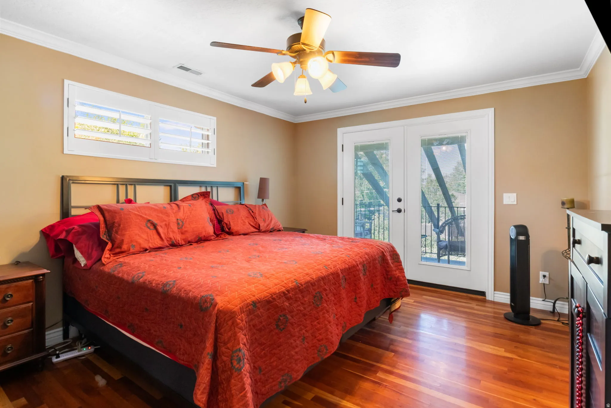 Bedroom featuring wood-finish flooring, a ceiling fan with integrated lighting, and a white crown molding accent