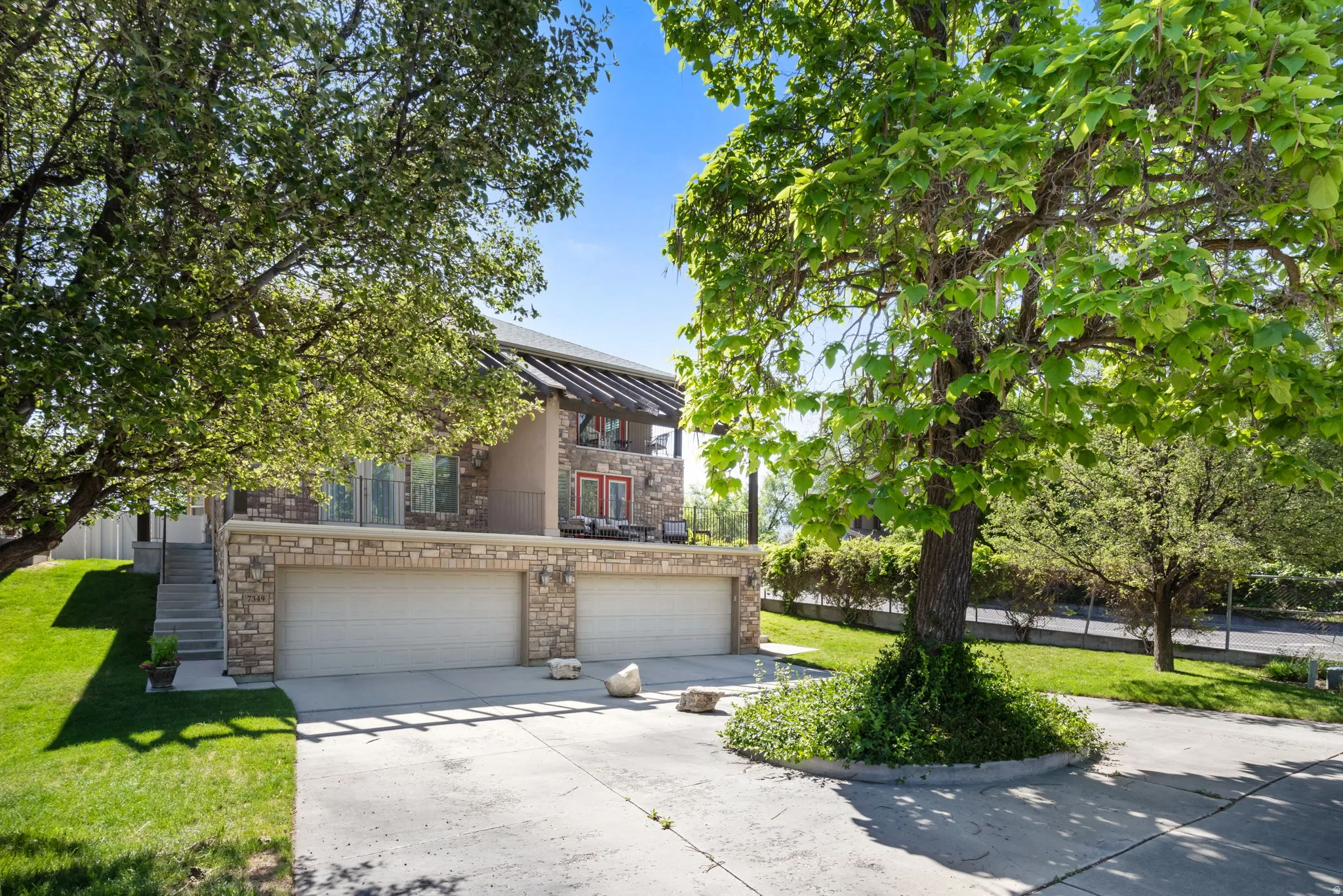 Two-story residence featuring a stone and stucco exterior