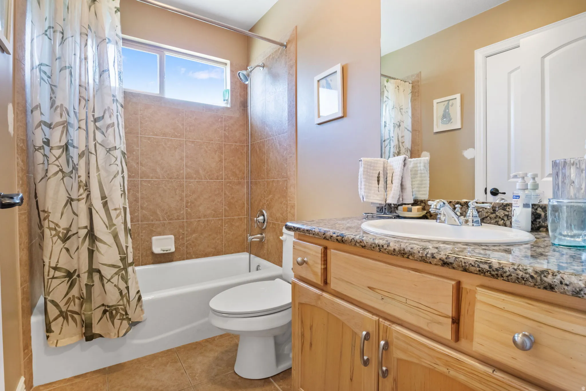 Bathroom featuring a single vanity with a granite countertop and wood cabinetry