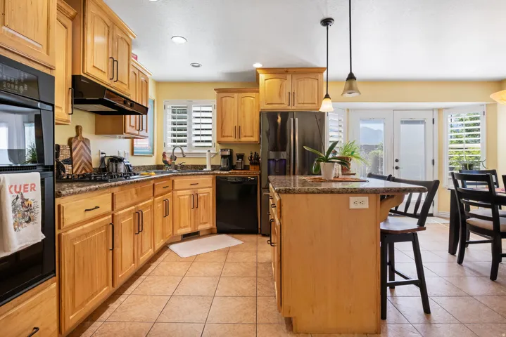 Kitchen featuring wood cabinetry, granite countertops, and tile flooring