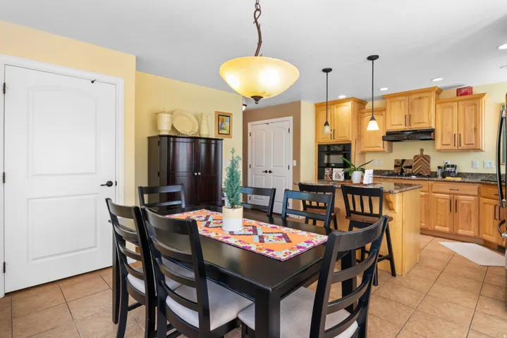 Open-concept dining area with tile flooring and a view of the kitchen